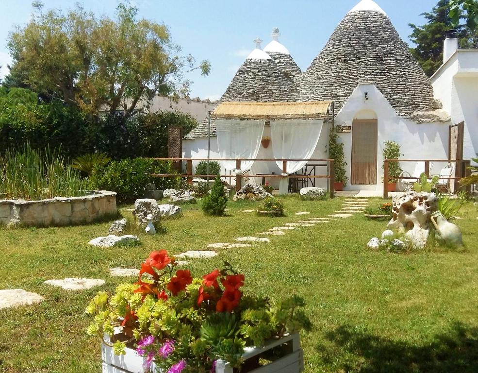 a house with a garden with flowers in the yard at TrulliColarossa in Alberobello