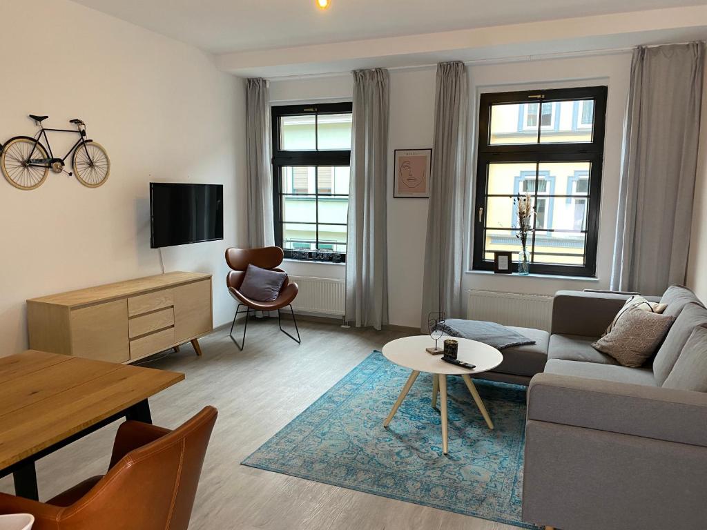a living room with a couch and a table at discovAVIR - Super Zentral mit Parkplatz, Küche, Netflix und mehr in Eisenach