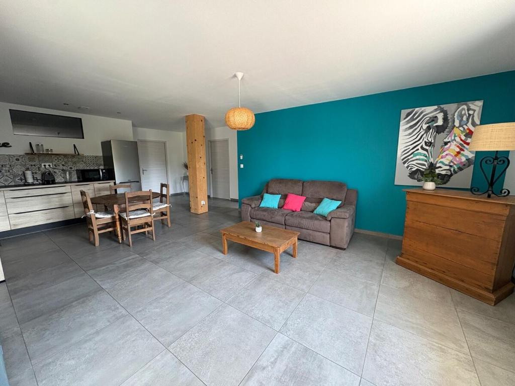 a living room with a couch and a table at Bas de villa 80m2 2 chambres secteur Ajaccio in Tavaco