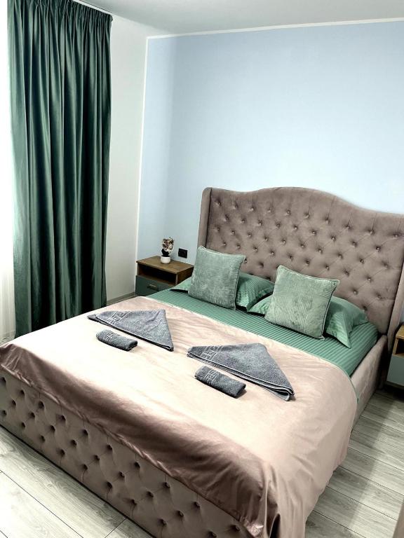 a large bed with two towels on top of it at CX Family Apartment in Bucharest
