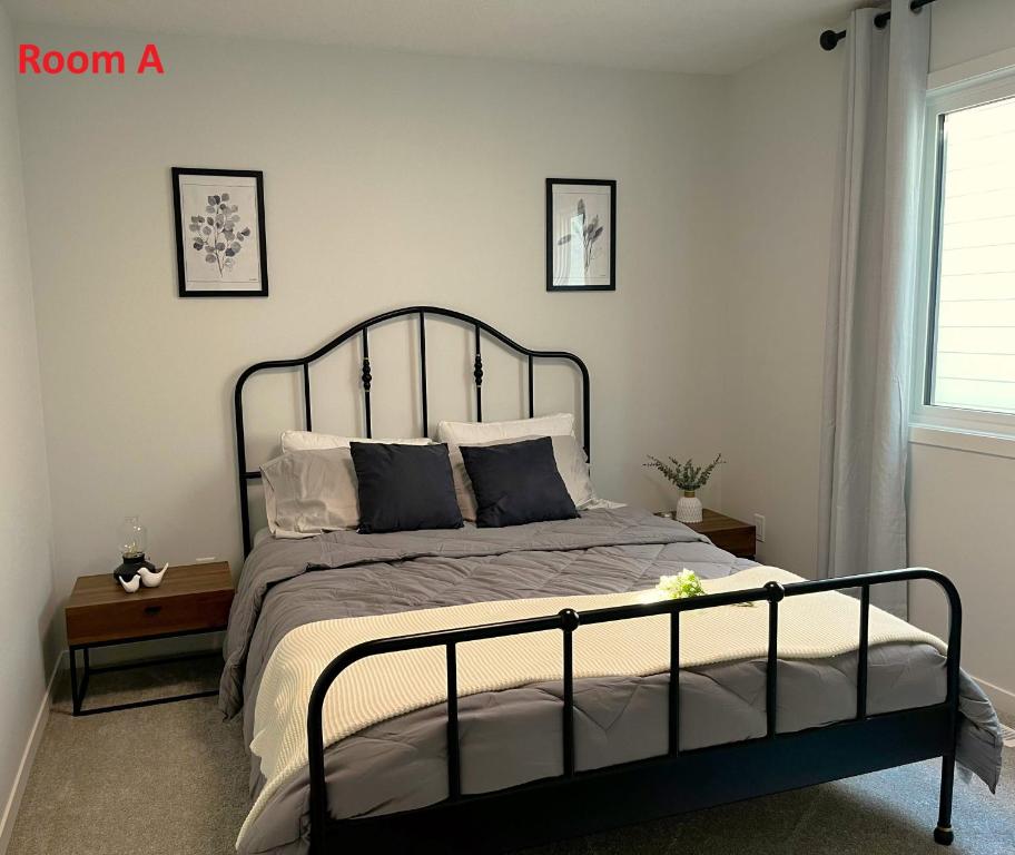 a bedroom with a bed with a black frame and pillows at Affordable Cozy Bedroom Close to YYC Airport in Calgary