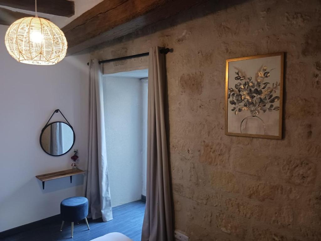 a room with a window and a mirror and a chandelier at Appartement de charme L'écrin du Castel Classé 3 étoiles in Azay-le-Rideau