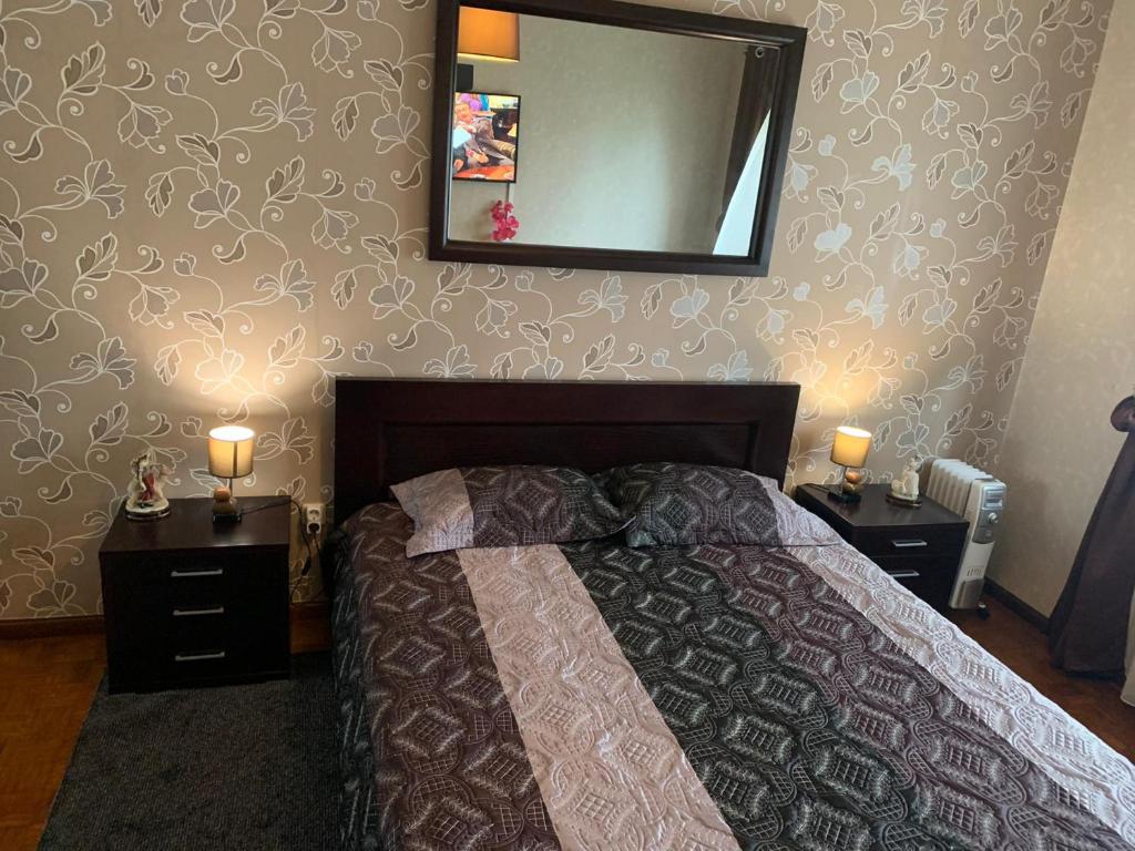 a bedroom with a bed and a mirror on the wall at Valadare in Bicas