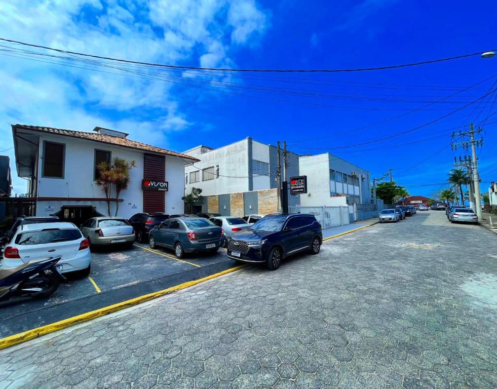 a street with cars parked in a parking lot at Pousada Vison Ubatuba - Praia Grande in Ubatuba