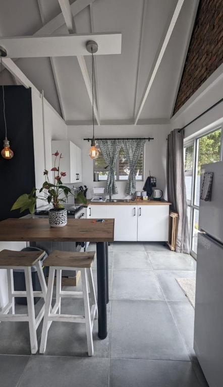 a kitchen with a wooden table and some chairs at Central Cottage Walmer in Gqeberha