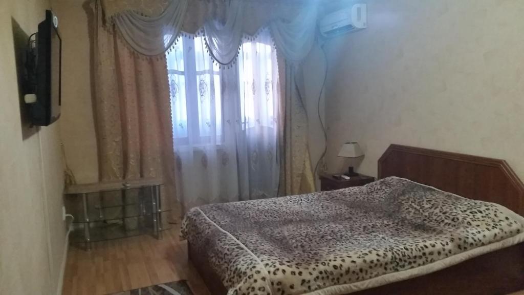 1 dormitorio con cama y ventana en Anis 1, en Khujand