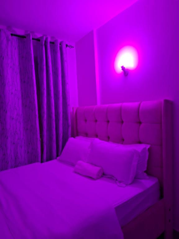 ナイロビにあるNGT Luxury homesのベッドルーム1室(ピンクのライト付きのベッド1台付)