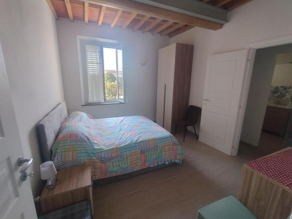un dormitorio con una cama y una ventana en Casa Verde, en Capannori
