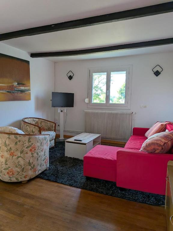 a living room with a red couch and a tv at Apartment in Jardres