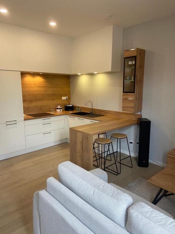 een keuken met witte kasten en een aanrecht met krukken bij Lou Occitan in Béziers