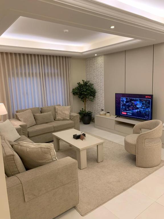 a living room with couches and a flat screen tv at Alarjan Dream in Riyadh