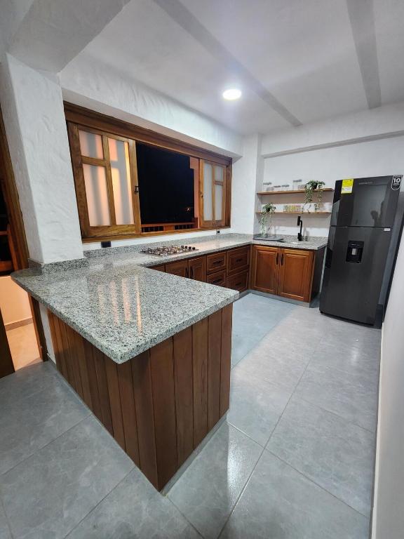a large kitchen with a counter top and a refrigerator at Apartment in Tamesis in Támesis