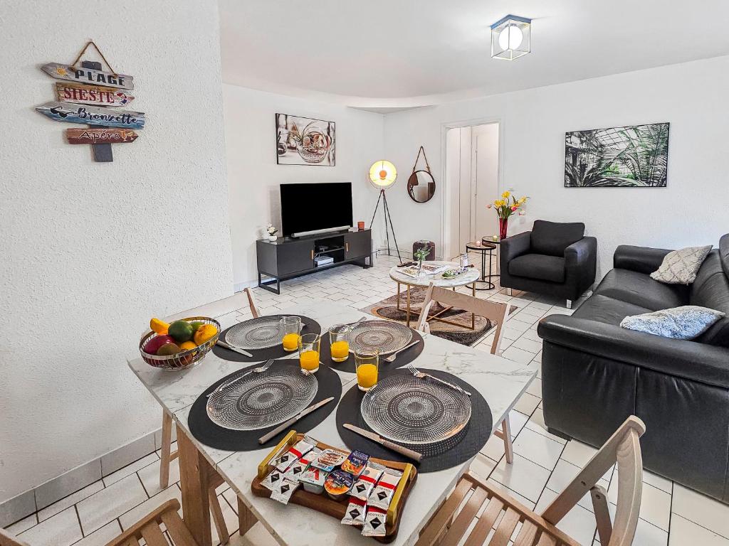 een woonkamer met een tafel en een bank bij Horizon sérénité - in Deauville