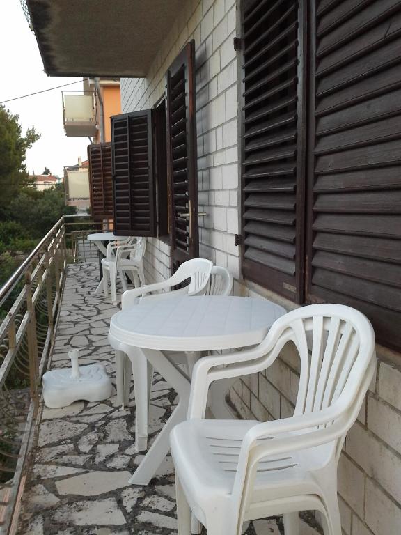 a row of white tables and chairs on a patio at Berto in Nerezine