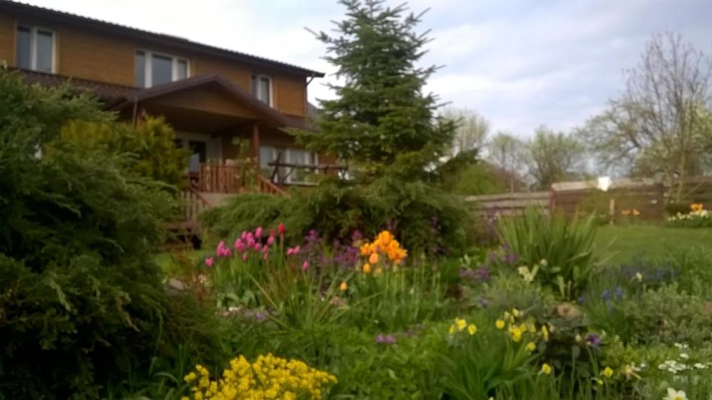 un jardín frente a una casa con flores en Trzecie Jezioro en Szypliszki