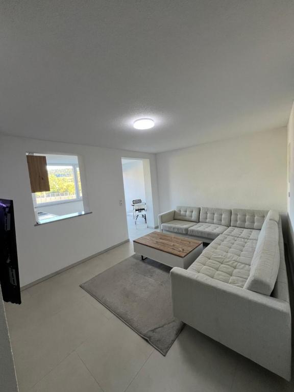 a living room with a couch and a table at Moderne helle 2 Zimmer Wohnung Neubau in Tuttlingen