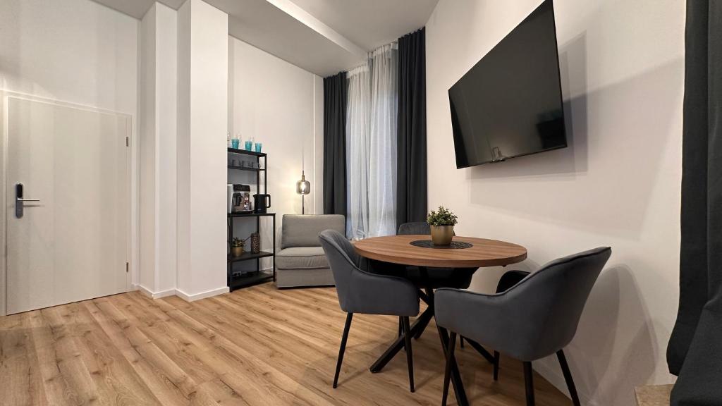 a dining room with a table and chairs and a television at Dream & Relax Apartment's Burg in Nürnberg