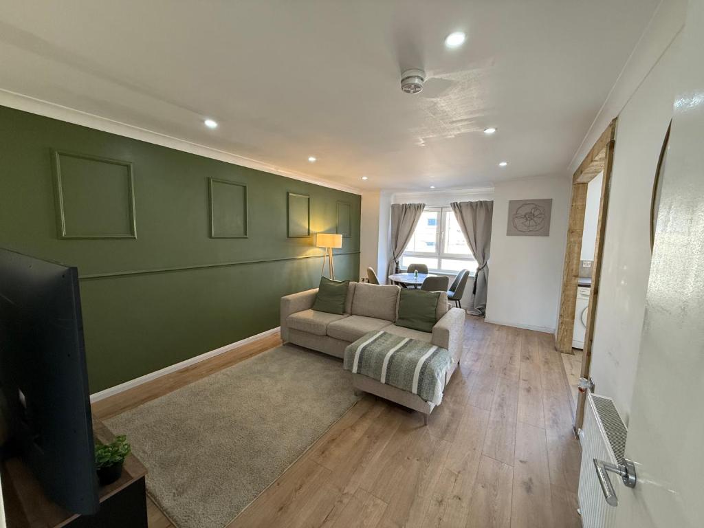 a living room with a couch and a television at Luxurious 2 bedroom, 8 mins from city centre in Glasgow