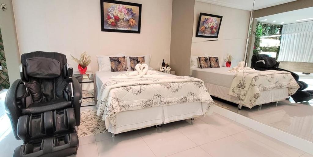 a bedroom with two beds and two chairs at Dream House in Ananindeua
