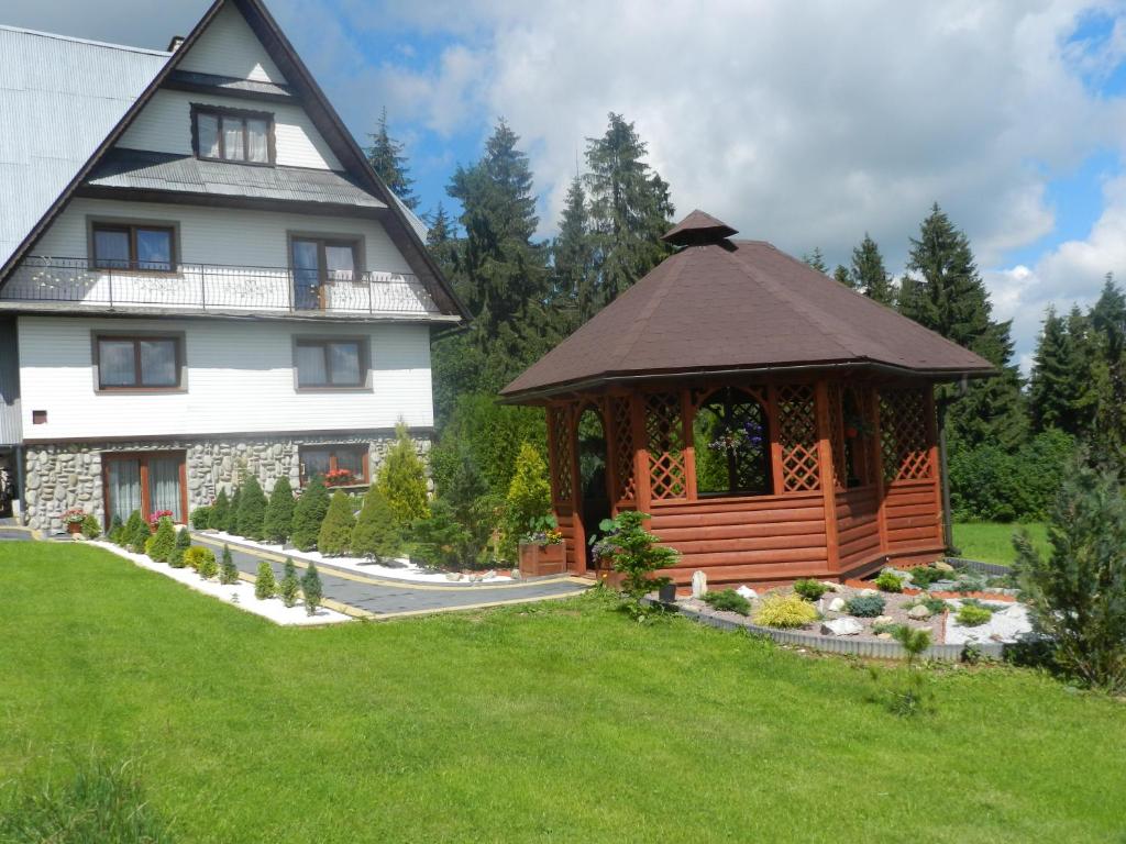 a gazebo in a yard next to a house at Pokoje Gościnne Pod Gubałówką in Nowe Bystre