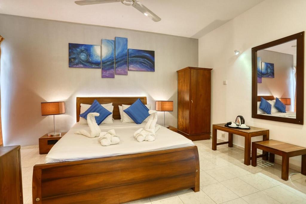 a bedroom with a large bed and a mirror at Mount Marina Villas - HAZEL in Galle