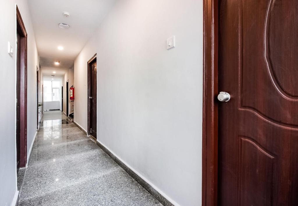 a hallway with a wooden door at Hotel O GACHIBOWLI BESIDE DLF in Hyderabad