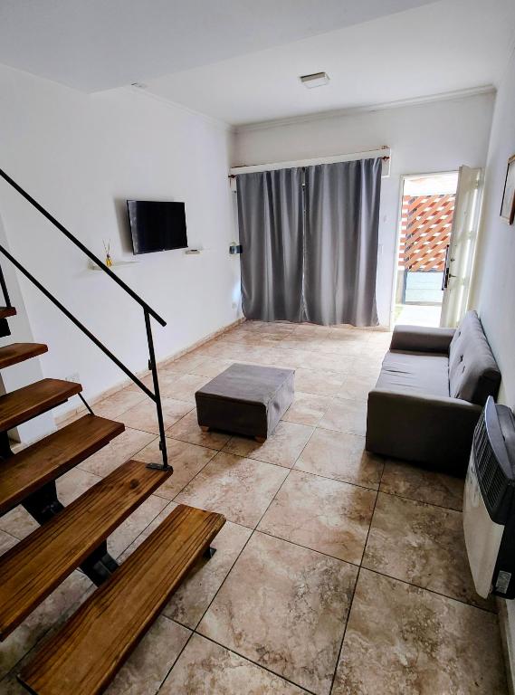 a living room with a couch and a tv at Depto Civora 5 in Villa Regina