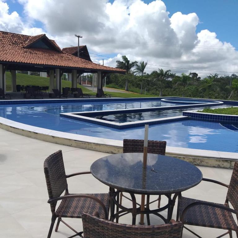a table and chairs in front of a swimming pool at George Ferreira in Chã Grande