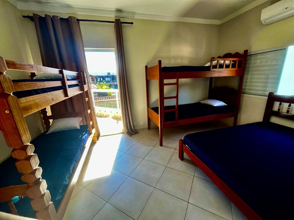 Dos literas en una habitación con ventana. en Casa de praia com piscina, en Guarujá