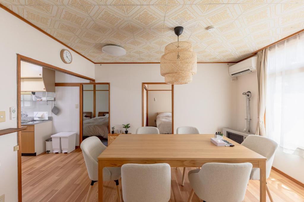 a dining room with a wooden table and chairs at Niko House Furano in Furano