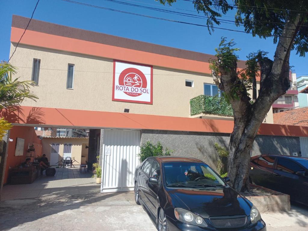 a car parked in front of a building at Hostel Rota do Sol in Cabo Frio