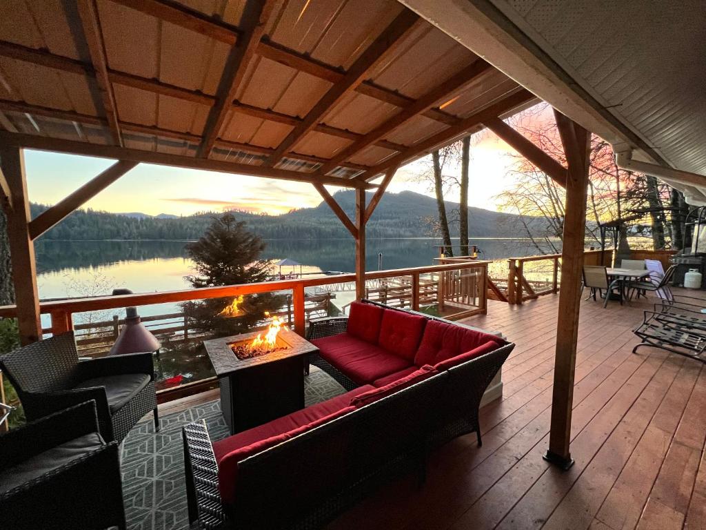 eine abgeschirmte Veranda mit einem roten Sofa und einem Kamin in der Unterkunft Mile 77 Cottages in Youbou