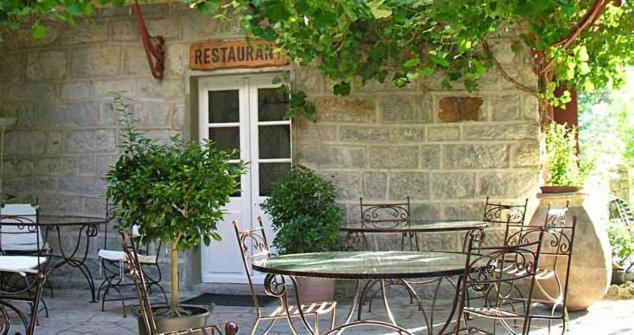 um pátio com mesas e cadeiras em frente a um edifício em Hotel Monte d'Oro em Vizzavona