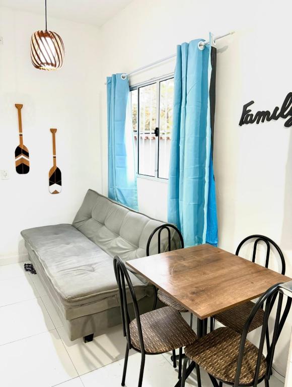 une pièce avec un canapé, une table et des chaises dans l'établissement Casa Beira Mar - Vista do Mar pela Janela da Sala, perfeita, em frente à praia da enseada Sesc Bertioga, à Bertioga