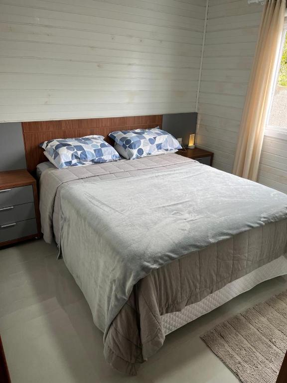 a bedroom with a large bed with blue and white pillows at Casa de Verão in Florianópolis