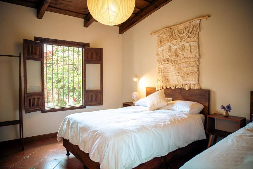 a bedroom with a large bed and a window at Casa del Sol Antigua in Antigua Guatemala