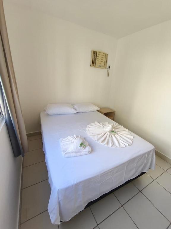a white bed with white sheets and pillows on it at Lindo e Confortavel Apto Ideal Torquato in Manaus
