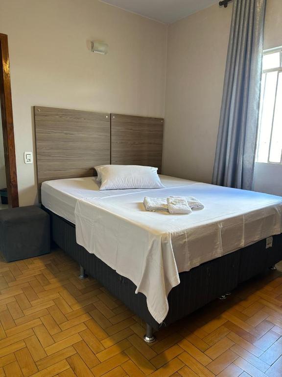 a large bed with two towels on it in a room at Hotel e Restaurante Santa Fé in Lages