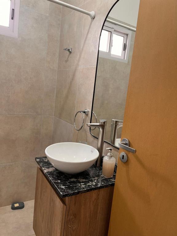 une salle de bain avec un lavabo et un miroir dans l'établissement Casa Las Breas del Champaquí, à Las Tapias