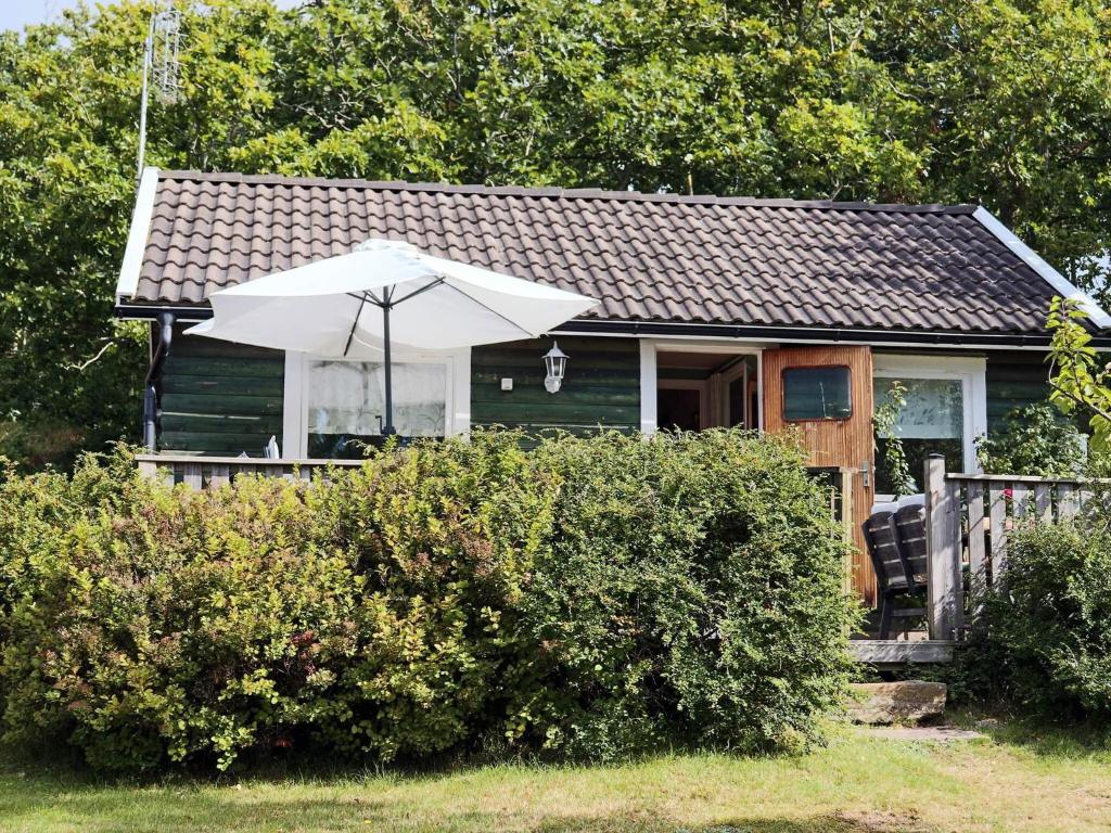 a small house with an umbrella in front of it at 4 person holiday home in UGGLARP in Ugglarp