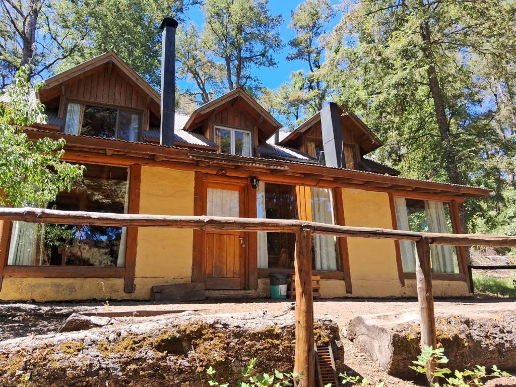 a house in the woods with a wood at Hosteria y Restaurante Hua Hum in San Martín de los Andes