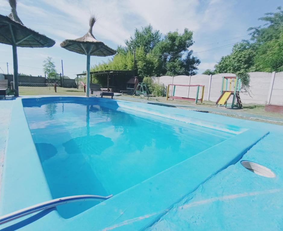 サン・ヴィセンテにあるQuinta Rufina San Vicenteの傘と遊び場のある青いプール