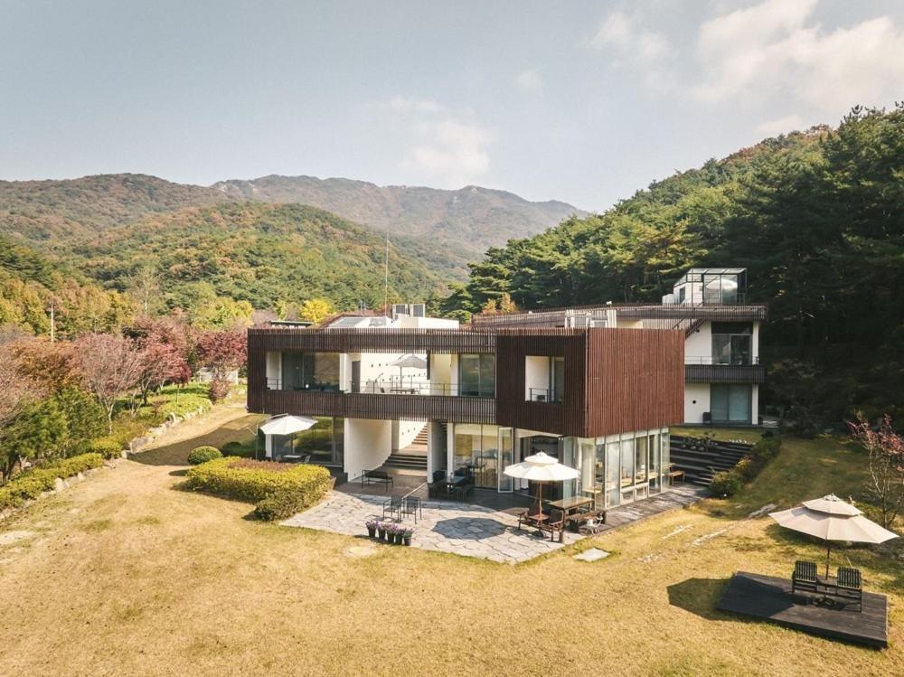 an aerial view of a house with mountains in the background at Seosan Soohwarim in Okkye-ri