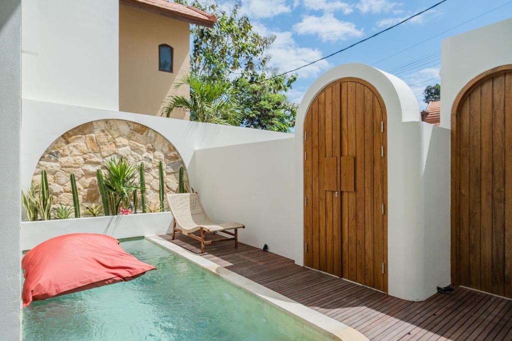 a house with a plunge pool and wooden doors at MarenaSol Villa Bingin, 1 BR Luxury Private Villa in Uluwatu