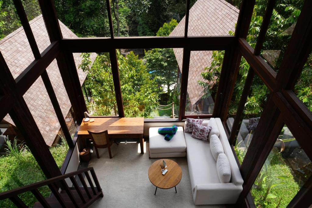 a living room with a white couch and a wooden table at Nunu Bali Eco Friendly Retreat in Canggu