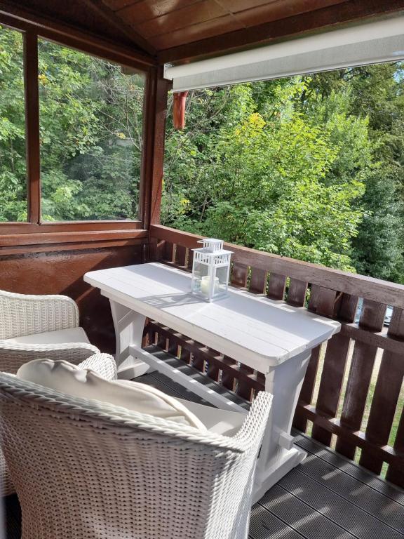 einen weißen Tisch und zwei Stühle auf einer Veranda in der Unterkunft Studio Furnica Sinaia in Sinaia