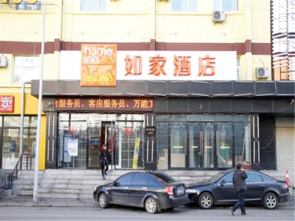two cars parked in front of a building at Home Inn Harbin Daowai Nanji Bus Station in Harbin