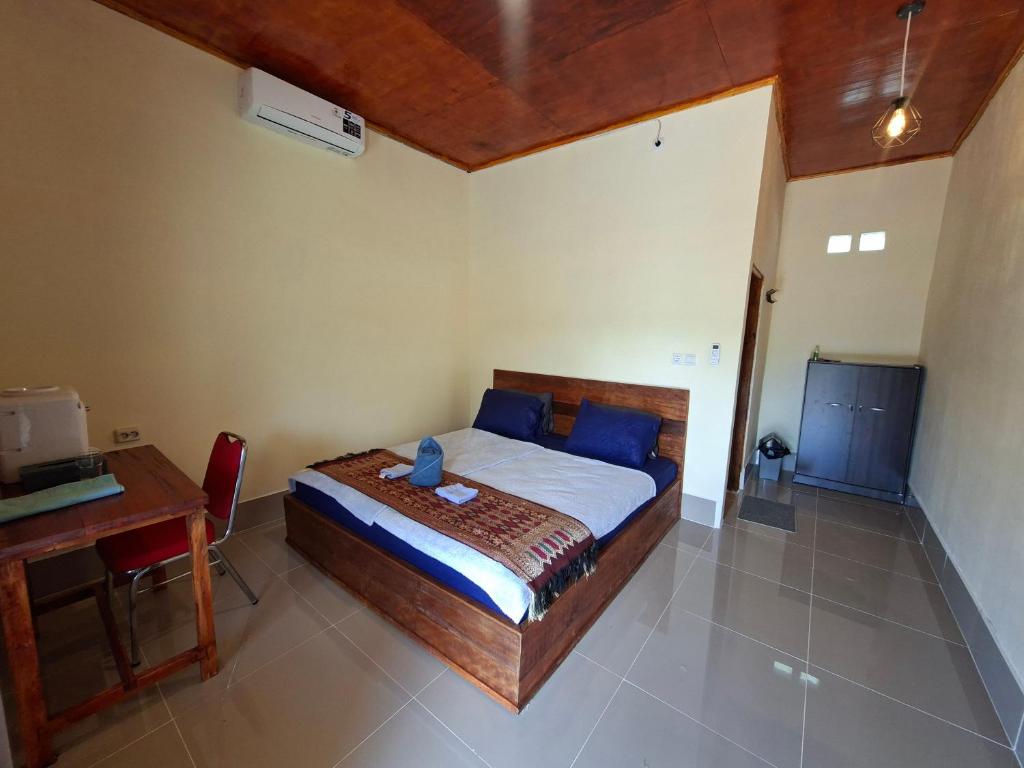 a bedroom with a bed and a table and a desk at Ekas Elen Homestay in Pulau Gilkaliantan
