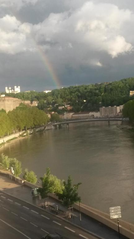 a rainbow over a river with a city at Cocon au pied de la Croix Rousse in Lyon