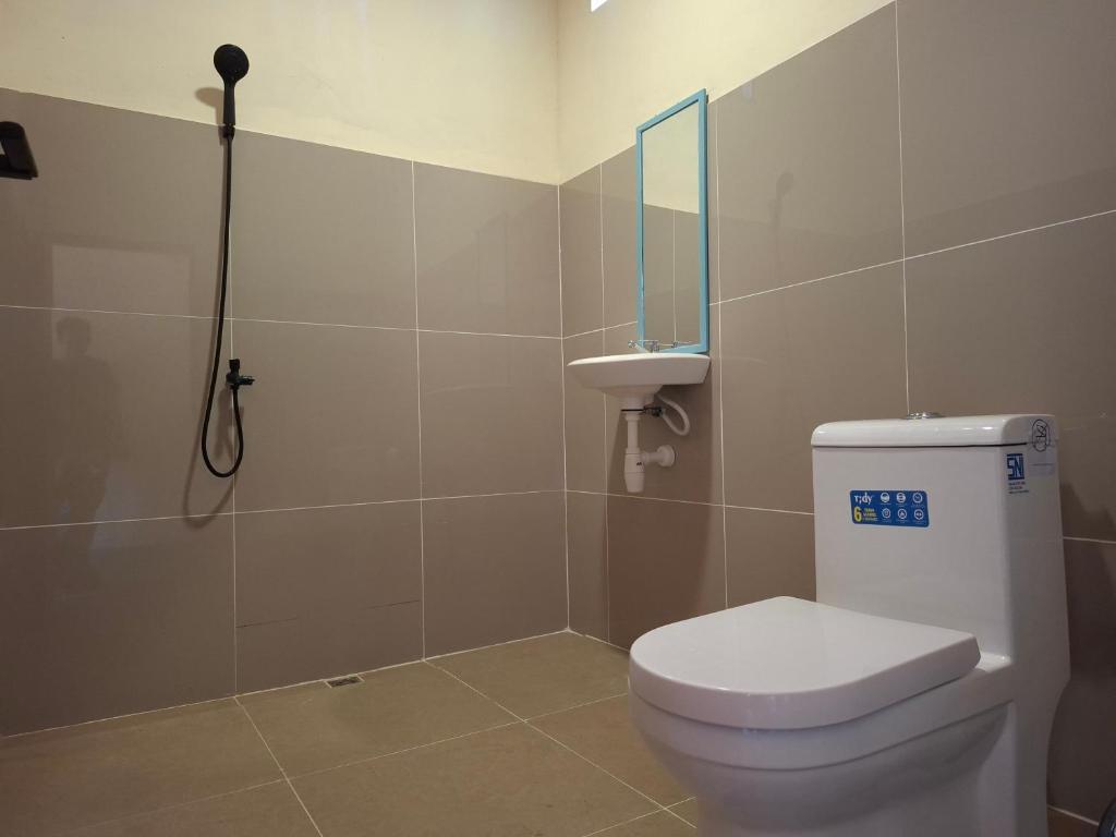 a bathroom with a toilet and a mirror and a shower at Ekas Elen Homestay in Pulau Gilkaliantan